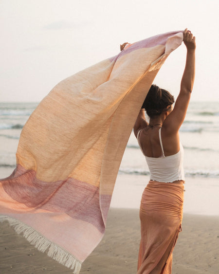 Woman holding handwoven Eri silk shawl on Goan beach