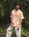 Man wearing Botanical Shirt Coral eco-printed with natural leaves and dyed with madder root, handmade in Auroville
