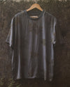 Botanical T-Shirt in slate gray hanging outdoors, eco printed with foraged leaves on textured cotton.
