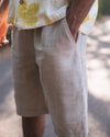 Close-up of linen shorts while worn, showing the pocket and leg drape